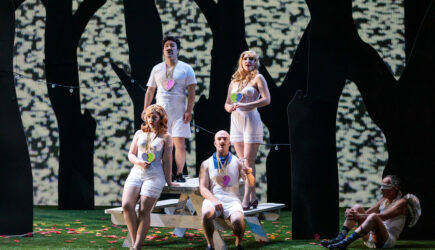 (L-R)F~1 (L-R) Fiordiligi (soprano Sarah Tucker), Ferrando (tenor Konu Kim) Guglielmo (baritone John Brancy), and Dorabella (mezz-soprano Samantha Hankey) with Cupid (Jack Missett) r in San Diego Opera's COSI FAN TUTTE (February, 2022). Photo by Karli Cadel.